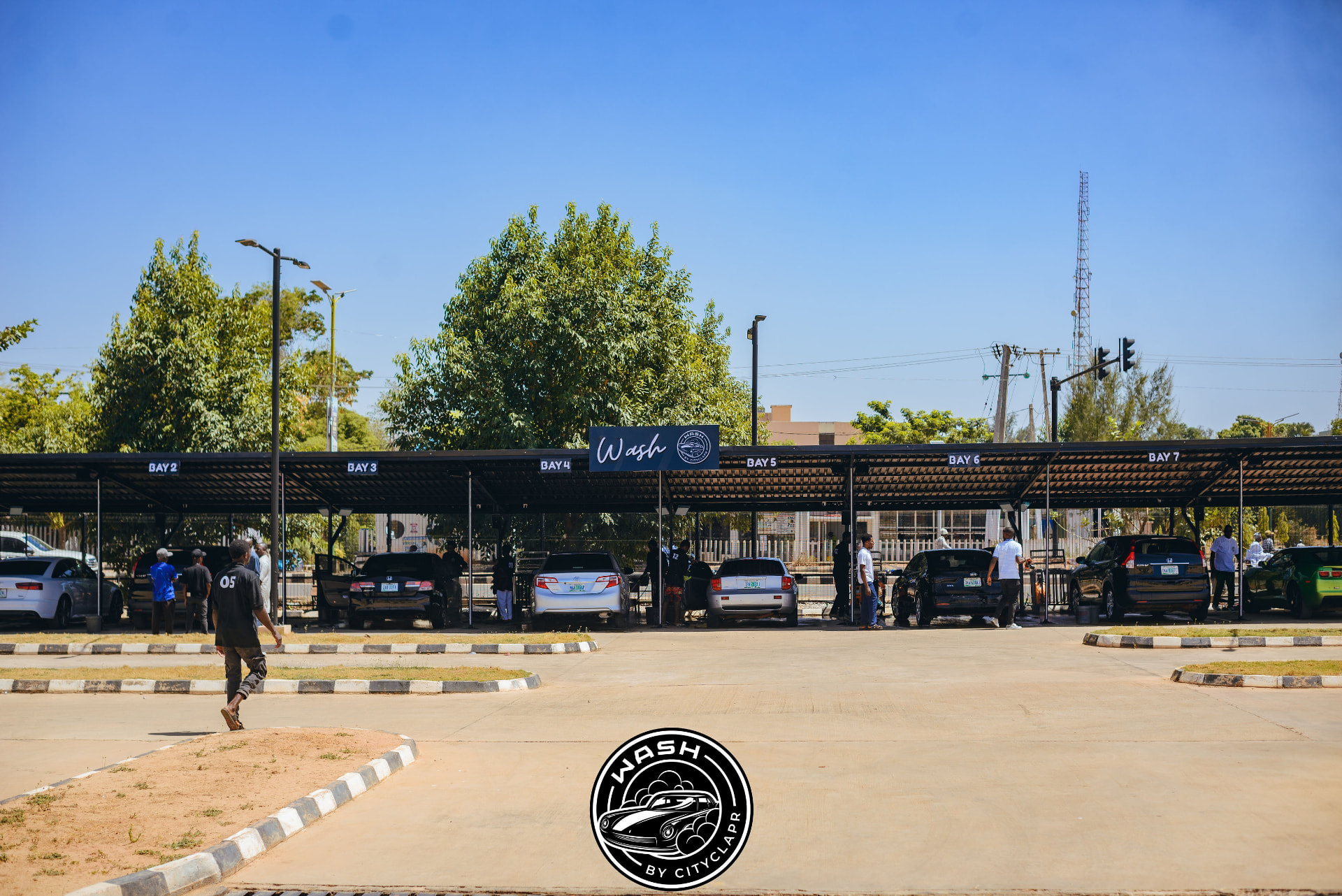 Wash by Cityclapr's covered service bays in Kaduna with cars and staff across the forecourt